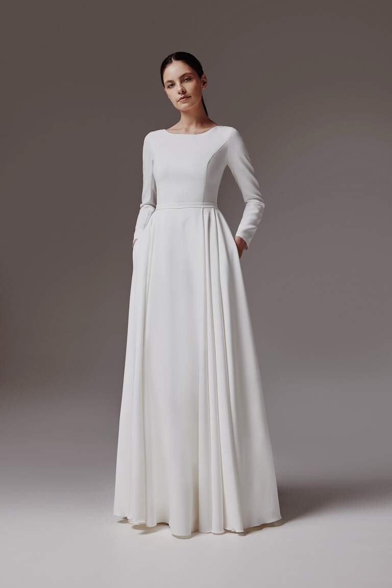 Adria minimalist dress front view emphasizing clean structural cut and pleats