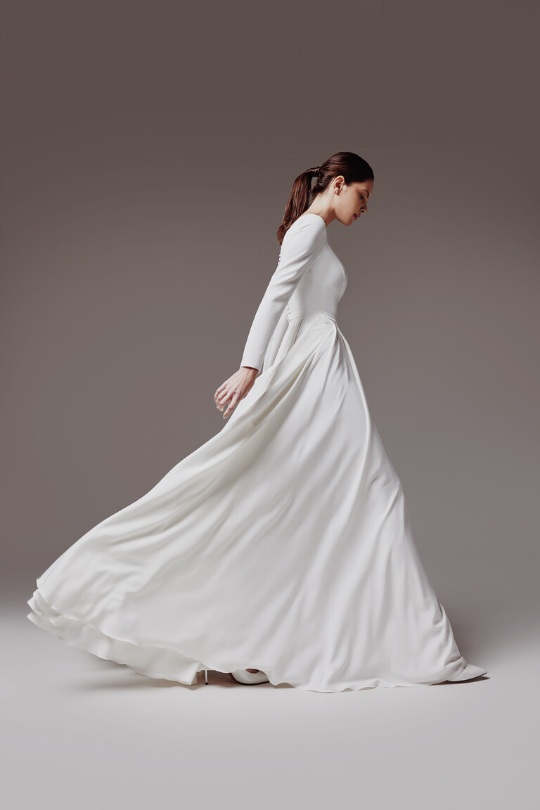 Side profile of Adria dress in motion showing voluminous skirt drape
