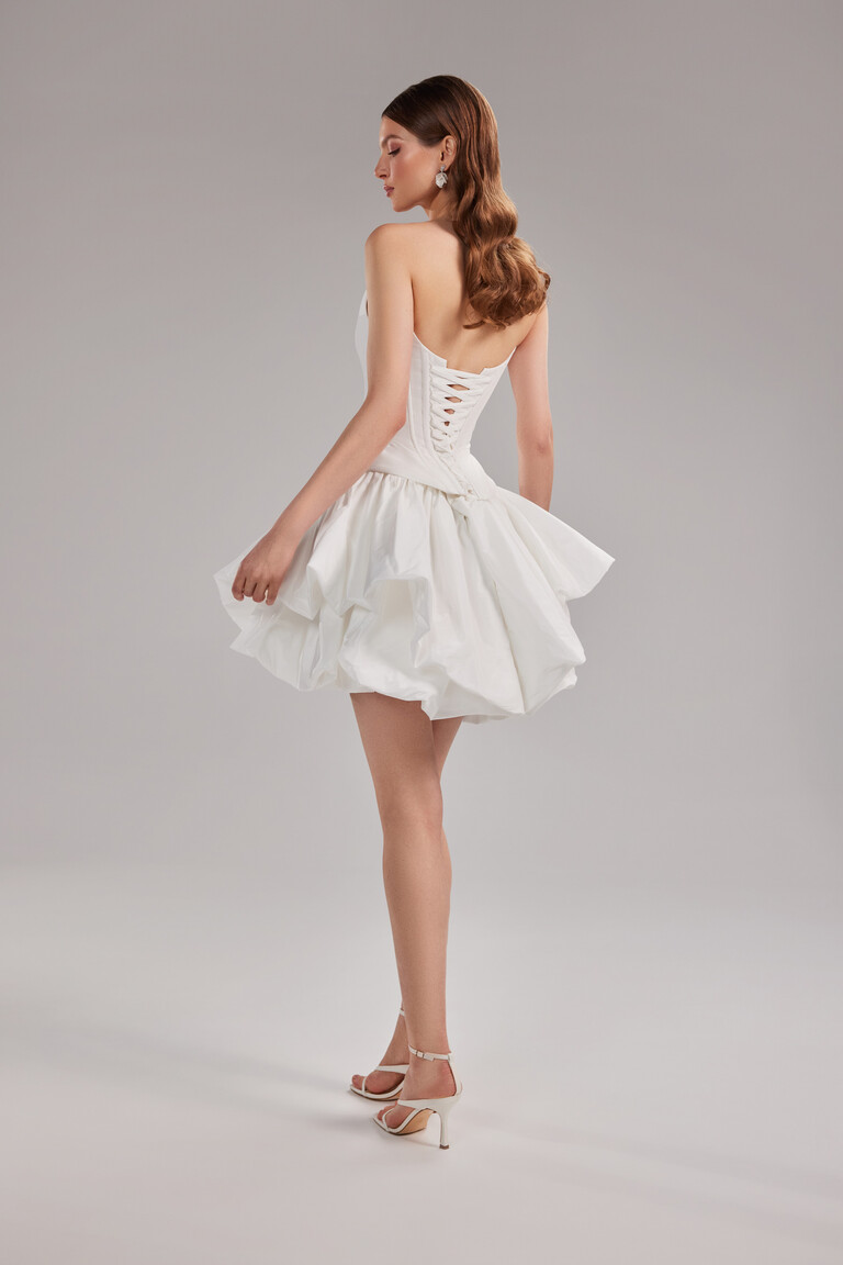 Full back view of the Amira Mini taffeta dress featuring the adjustable lace-up corset back and short bubble skirt by Unona.