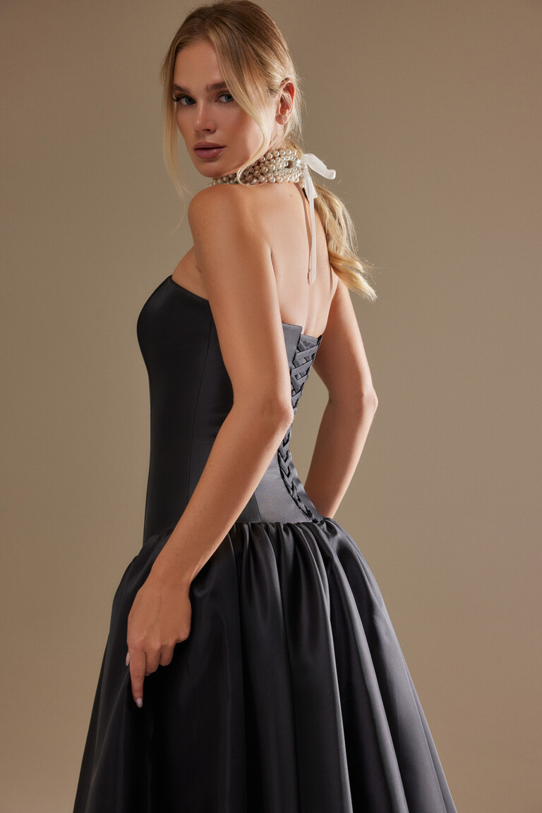 Back three-quarter view of the Francesca black evening gown highlighting the elegant lace-up corset back and full satin skirt.