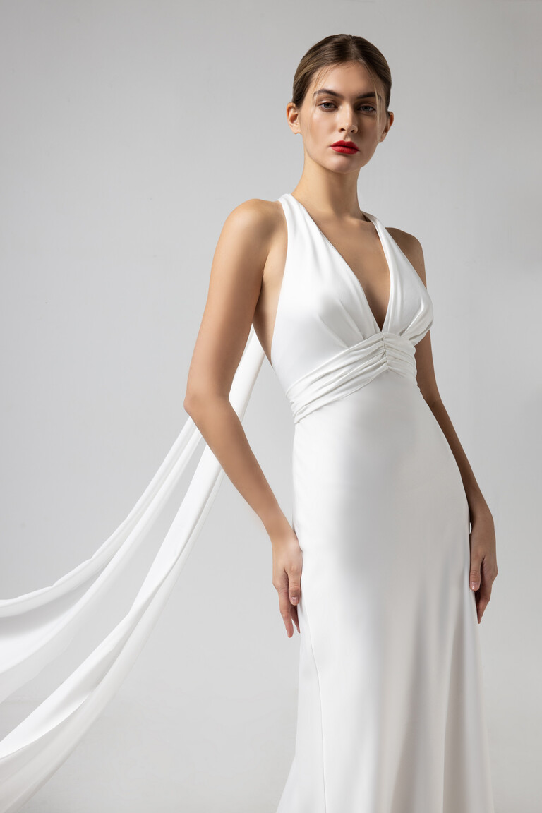 Medium shot of Athena bridal gown showing plunging neckline and draped shawl extension