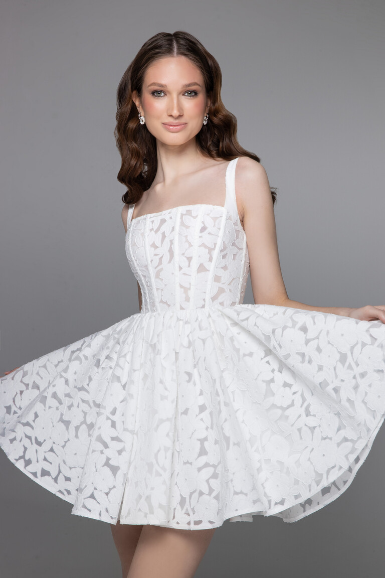 Ruta mini lace dress medium shot with model holding flared A-line skirt to show volume