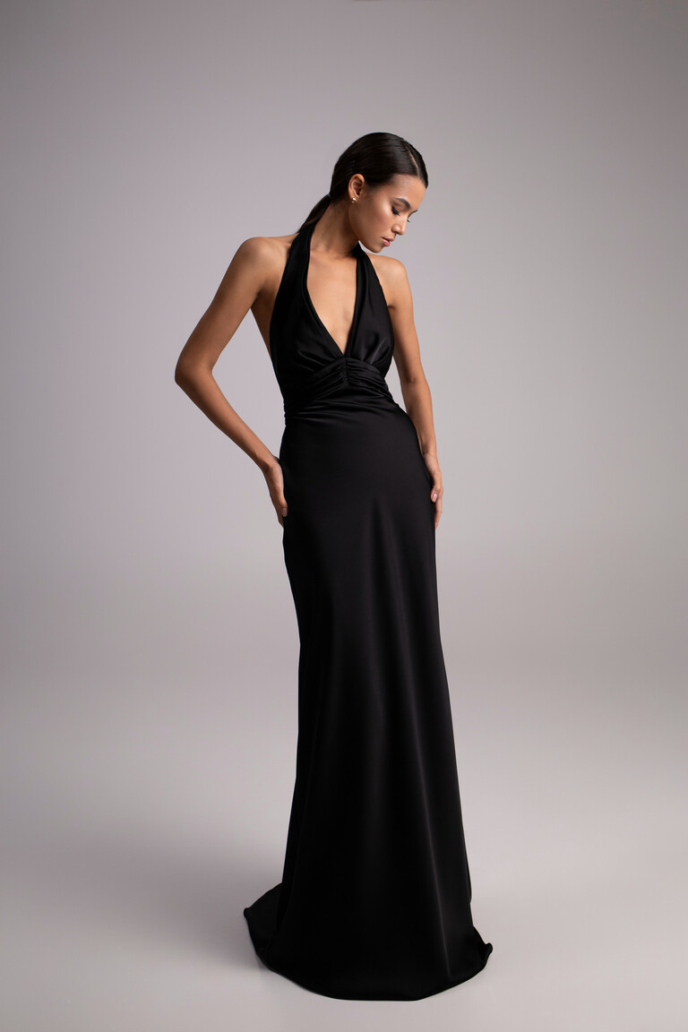 Three-quarter view of Athena fitted black evening gown highlighting silk satin sheen and draping