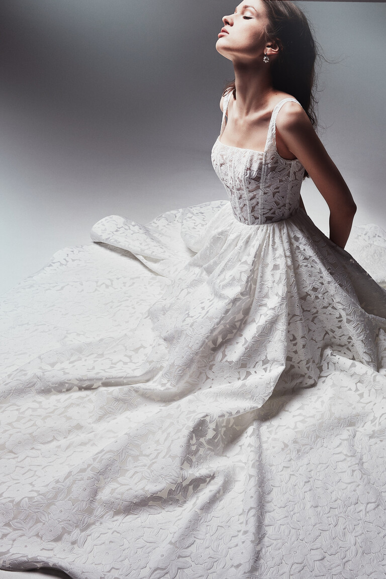 Unona Ruta wedding dress seated pose highlighting corset bodice and lace skirt