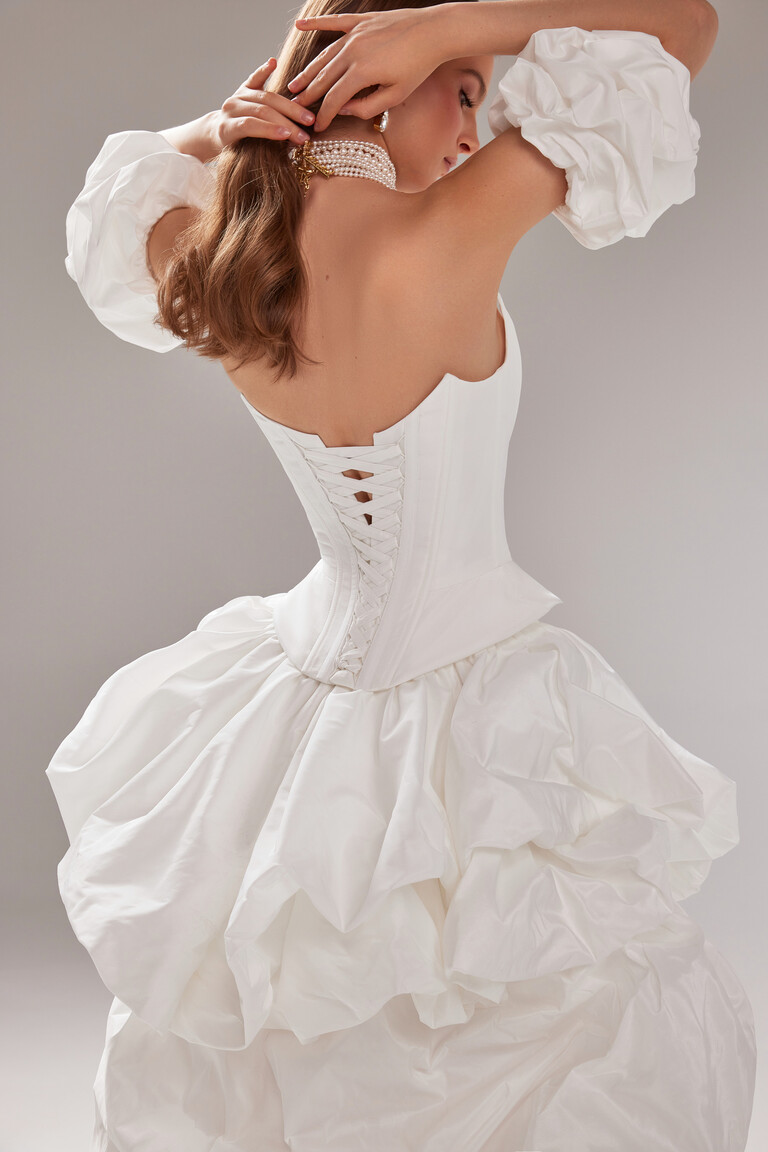 Back view of the Unona Amber bridal gown showing the strapless corset with lace-up detail and full gathered taffeta skirt.