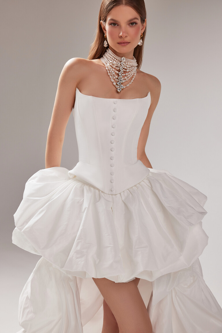 Strapless look of the Amber off-white wedding dress from the front, showcasing the structured corset and voluminous bubble skirt.