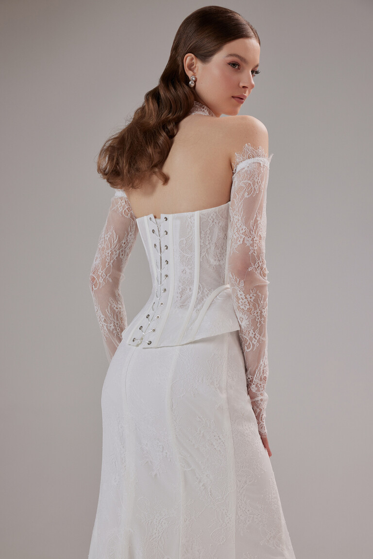 Unona Prima ivory lace wedding gown with an adjustable lace-up back and elegant off-the-shoulder long sleeves.