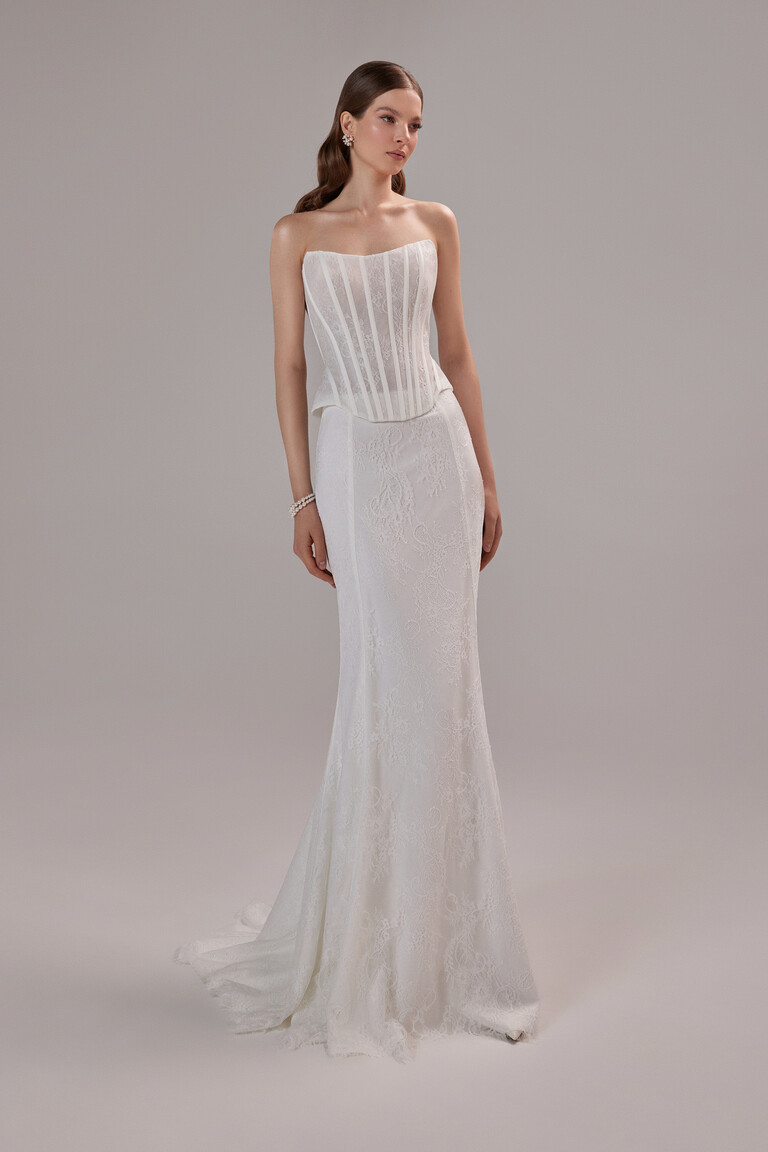 Full front view of the Unona Prima ivory lace dress showcasing its strapless corset and elegant floor-length skirt.
