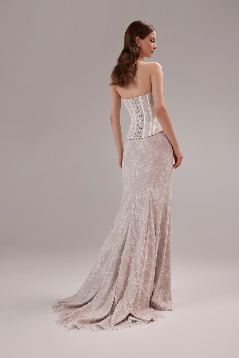 Full back view of the Unona Prima sleeveless wedding dress in beige, featuring the adjustable lace-up corset and long lace train.