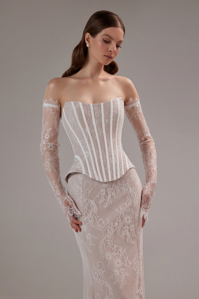 Front view of the Unona Prima two-piece lace dress in beige featuring a strapless corset top and fitted floor-length skirt.