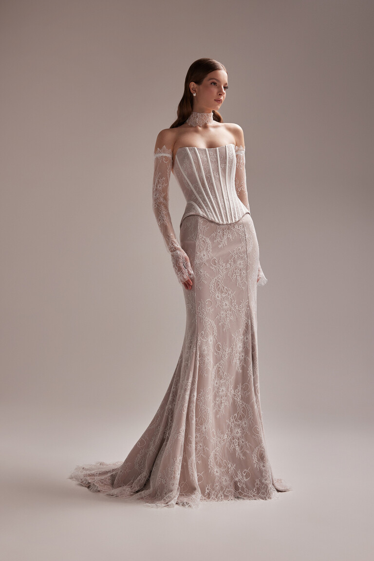 Three-quarter view of Unona Prima beige lace mermaid gown showcasing the structured corset and detached off-shoulder sleeves.