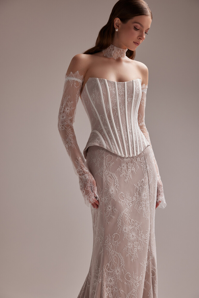 Unona Prima beige lace corset dress with a sweetheart neckline and detached long sleeves shown in a three-quarter front view.