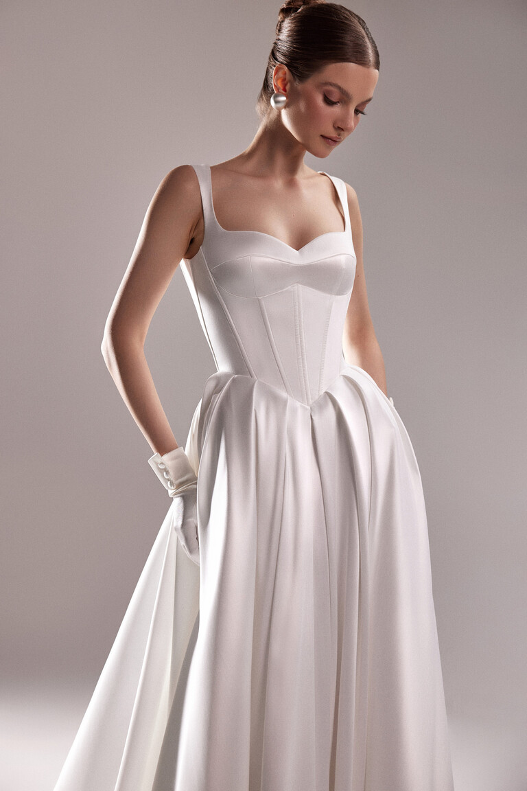 Detailed front view of the Unona Antonia corset bridal gown in off-white showing the sweetheart neckline and convenient side pockets.