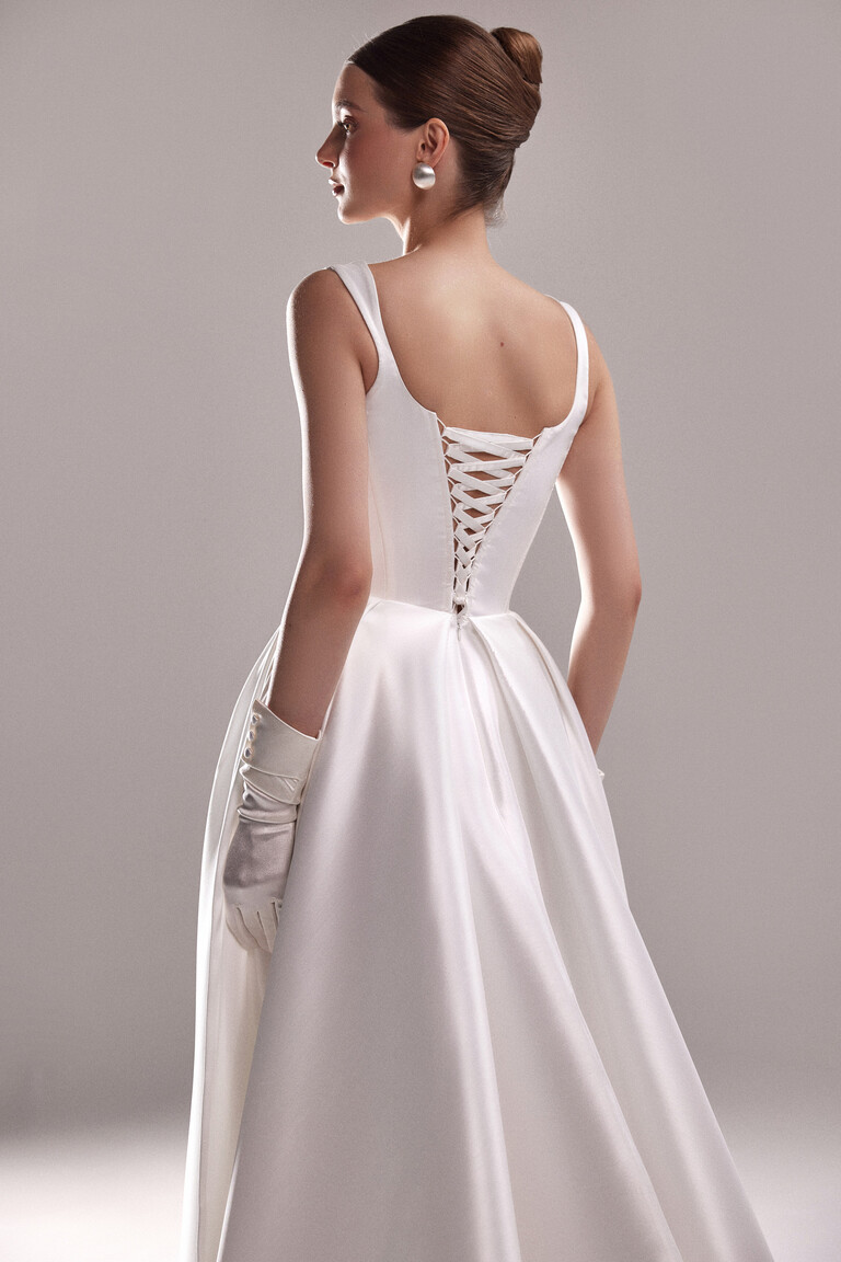 Back view of the Unona Antonia wedding dress in off-white mikado satin featuring the elegant open back with corset lace-up detail.