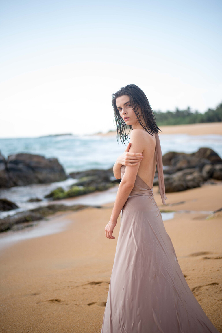 Back view of the Unona Mary backless halter dress in ash silk featuring the deeply open back and long neck ties.