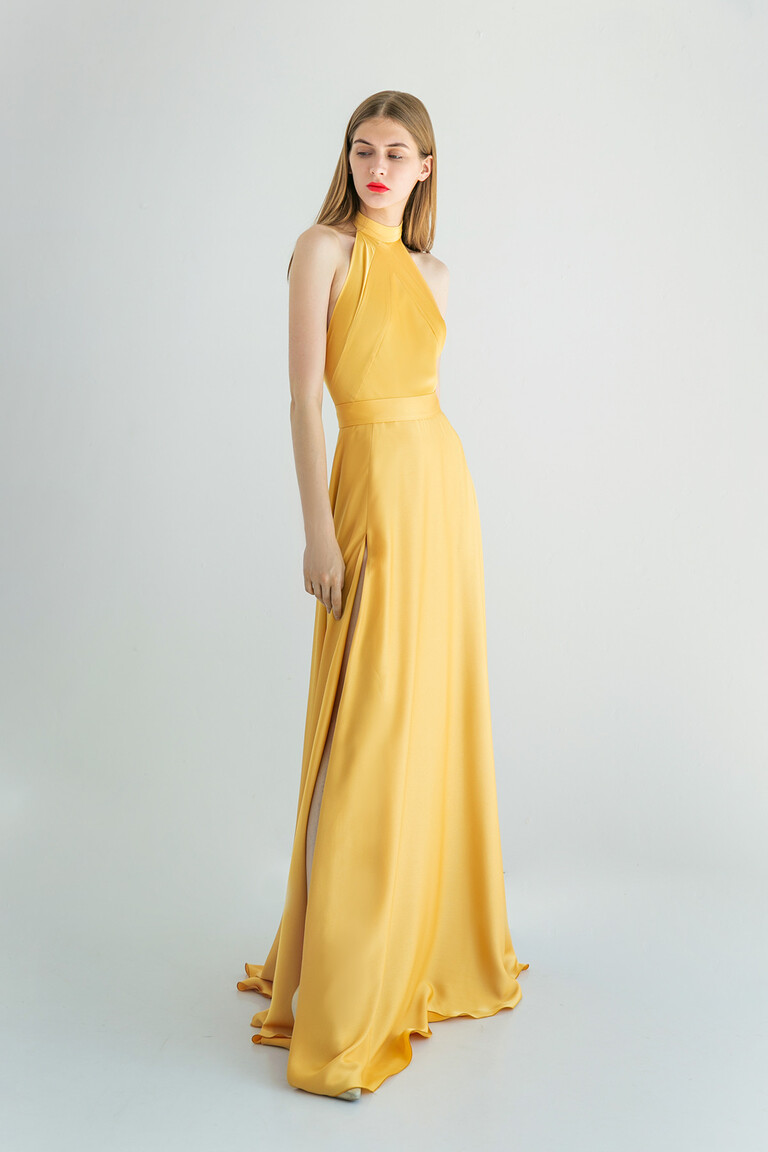 Three-quarter front view of the Unona Mary yellow silk evening gown, highlighting its sleeveless halter top and A-line skirt.