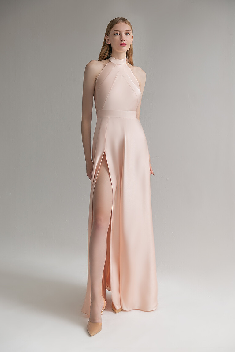 Front view of the Unona Mary peach silk halter dress featuring a sleeveless bodice and a dramatic high thigh slit.