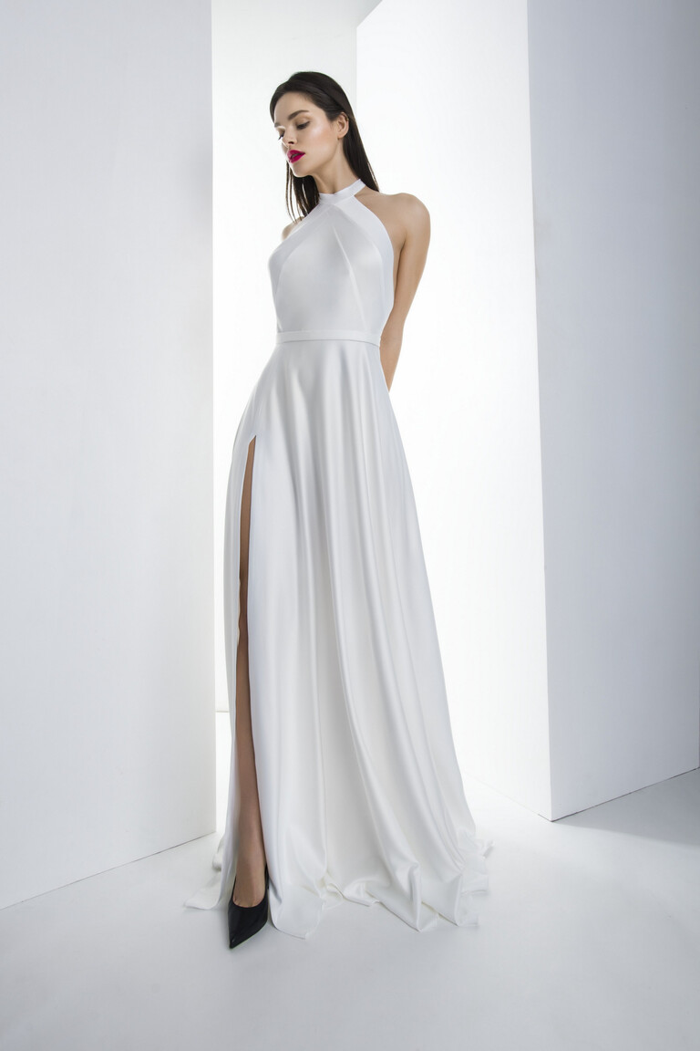 Model wearing the Unona Mary ivory silk A-line wedding dress with a high halter neck and floor-length skirt