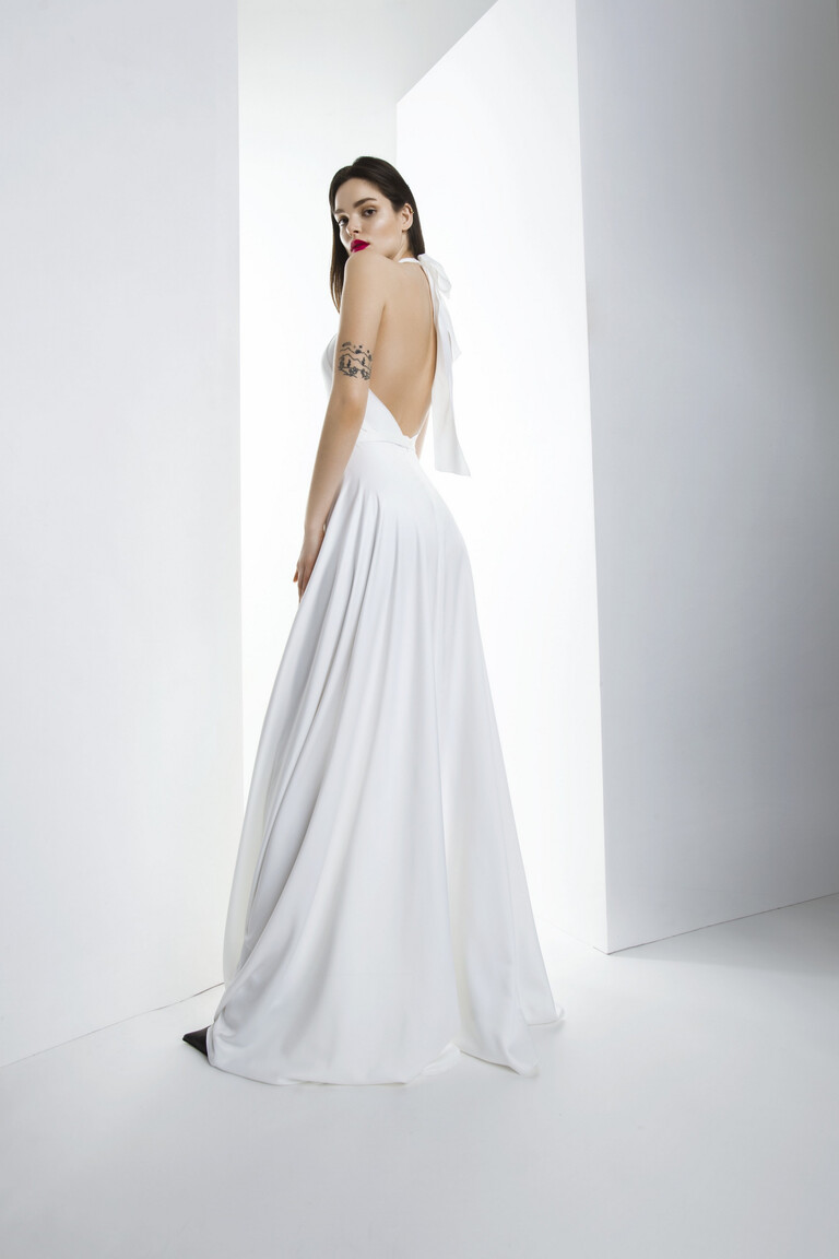 Back view of the Unona Mary ivory silk dress showcasing the backless design and a large bow tie at the neck