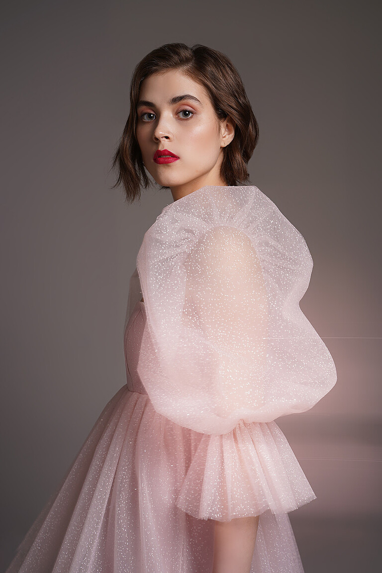 Side detail of the Lessi powder dress puff sleeve. Shows sheer shimmering mesh with glitter and ruffled cuffs.