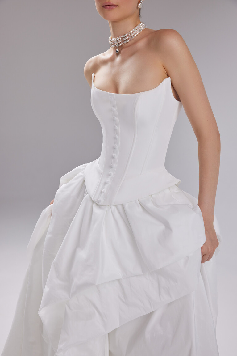 Medium shot of the Sonara off-white wedding dress showing the basque waistline and modern taffeta draping.