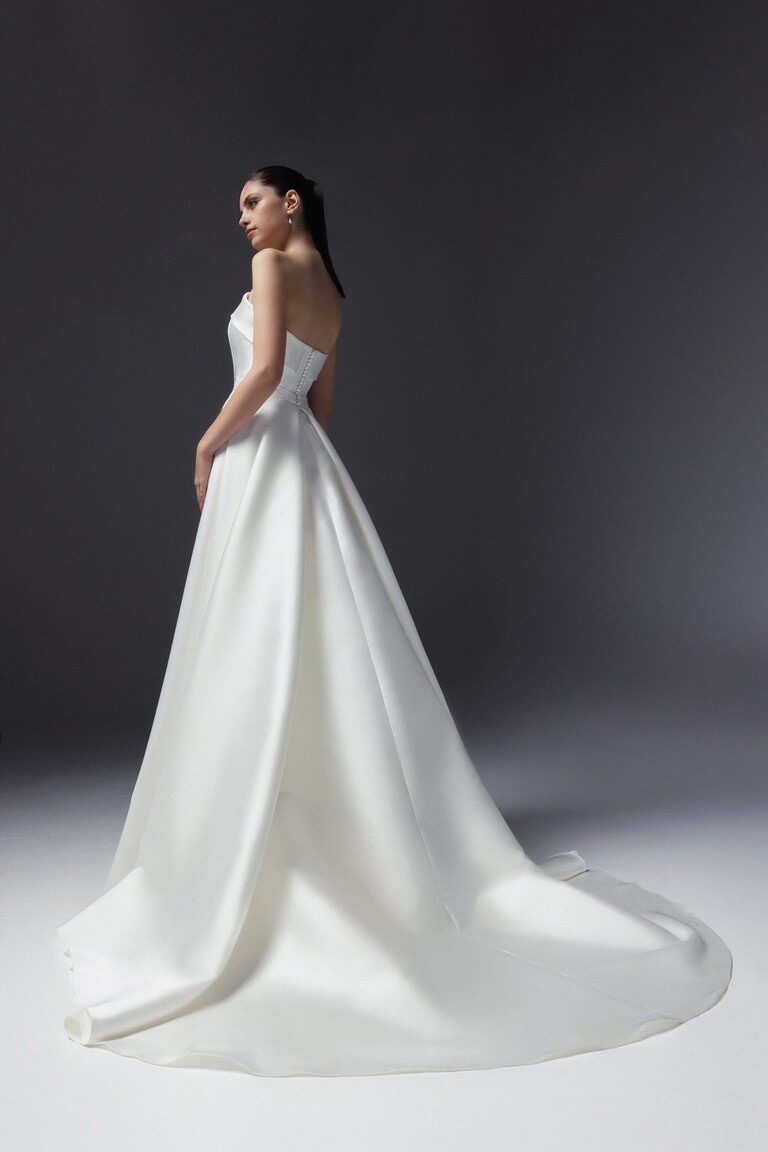 Back view of Unona Gala off-white mikado wedding dress showing detachable overskirt, train and buttons