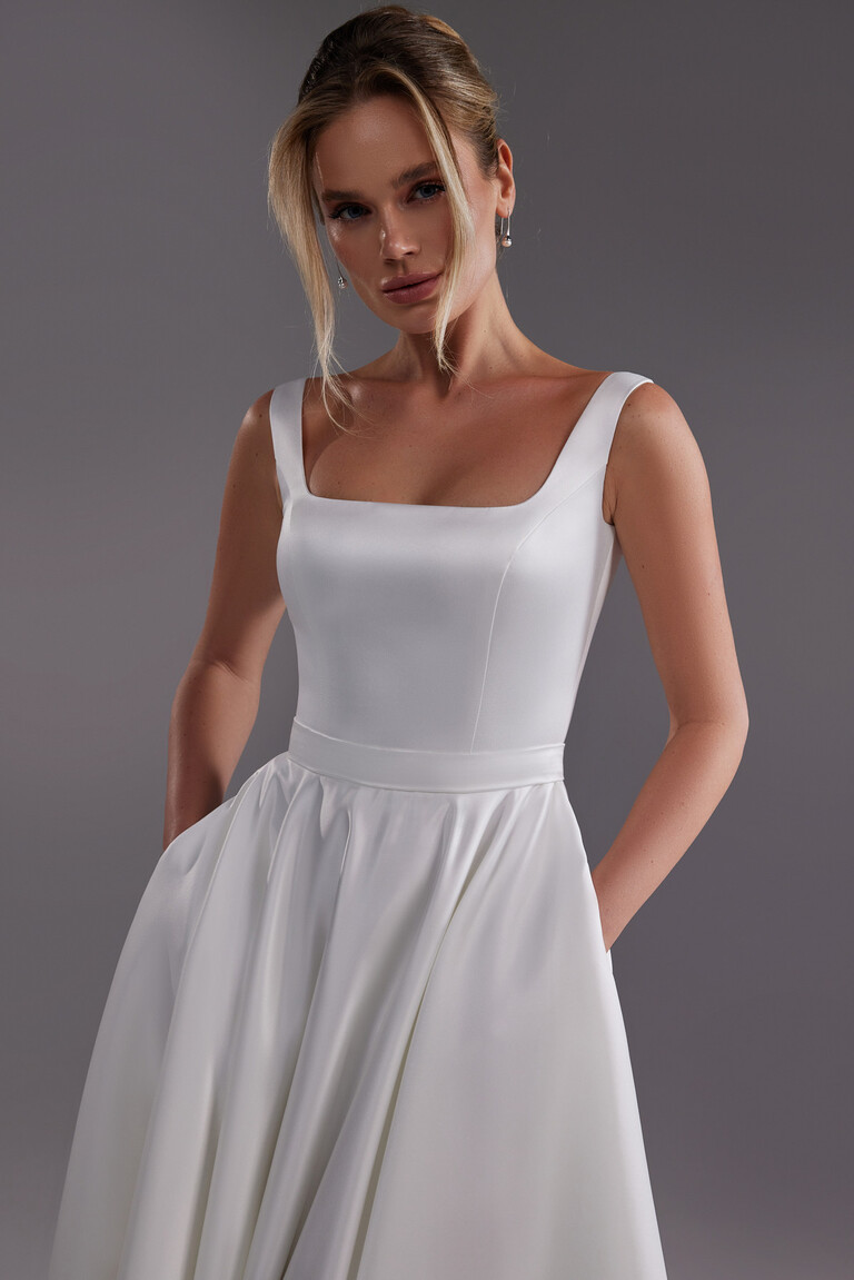 Close up front view of Vlada off-white square neck wedding dress showcasing the sculpted bodice and hidden pockets