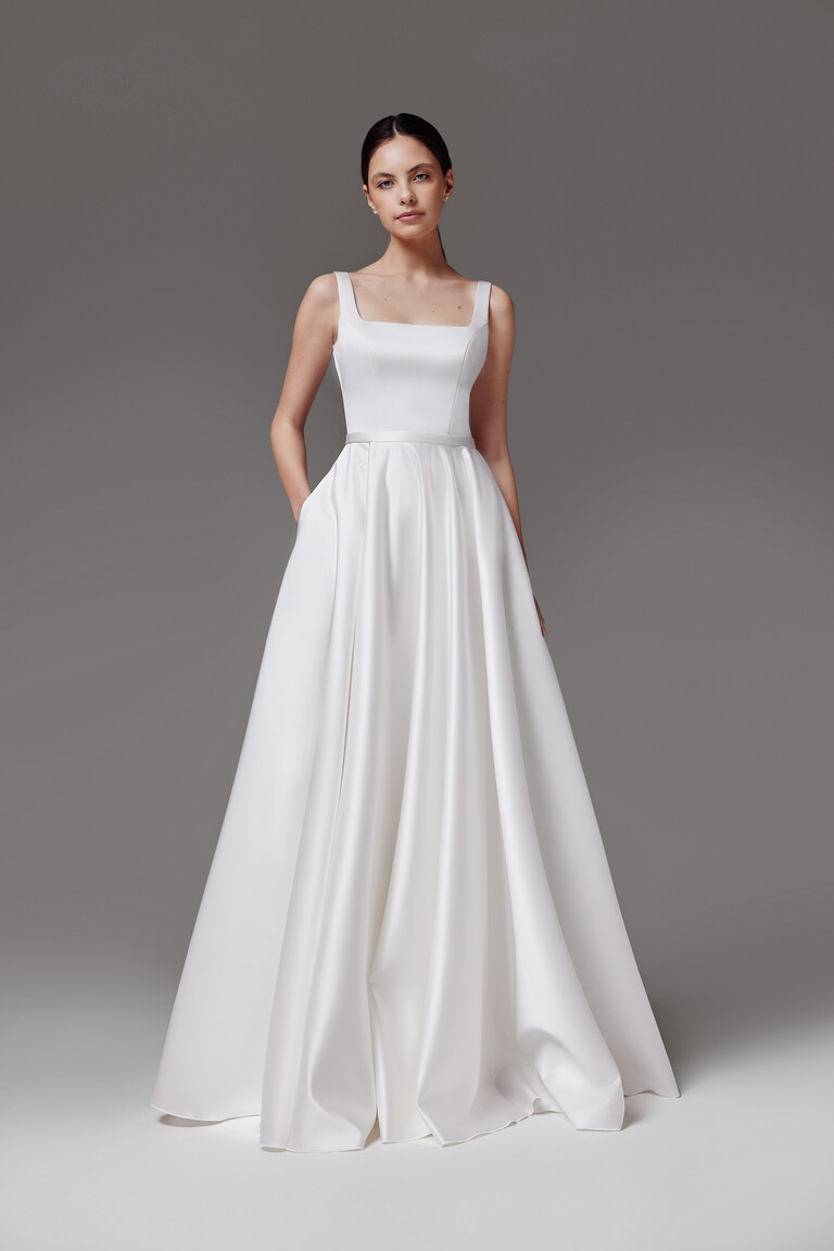 Full length front view of Vlada off-white A-line bridal gown showing the voluminous satin skirt and hidden pockets