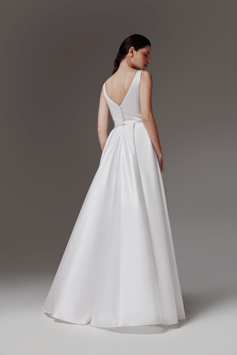 Full length back view of the Vlada off-white A-line wedding dress with a deep V-back and elegant button train