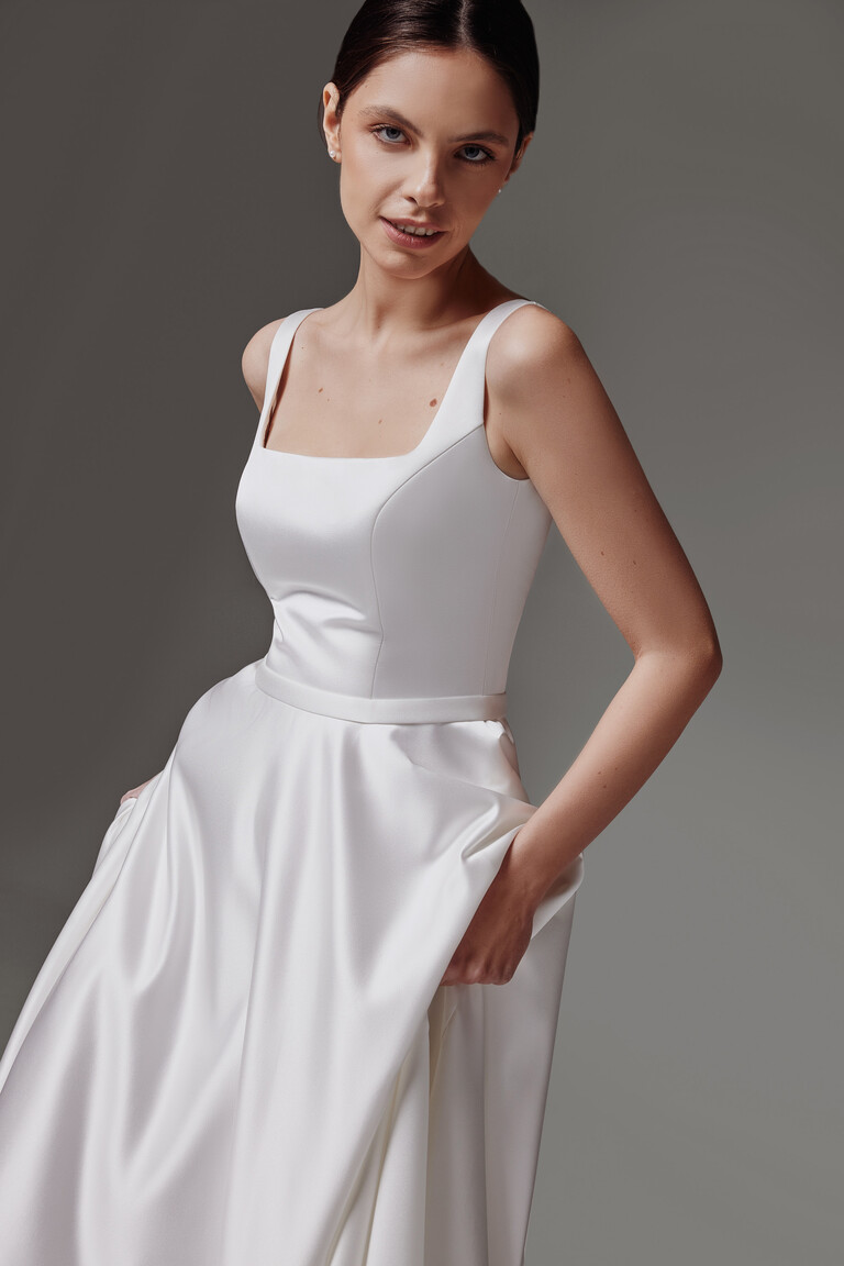 Angled front view of Vlada off-white sleeveless wedding dress highlighting the sculpted satin bodice by Unona