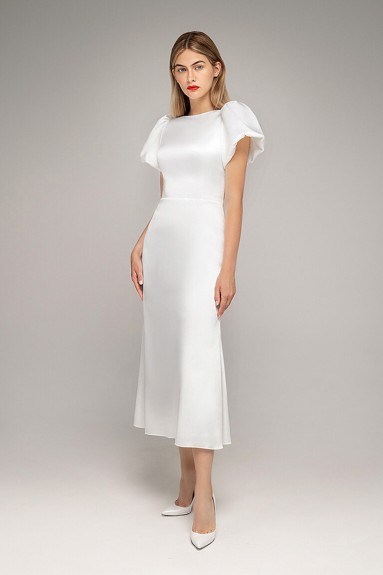 Full length view of Audrey-1 midi ivory bridal dress by Unona. Semi-fitted silhouette with puff sleeves.
