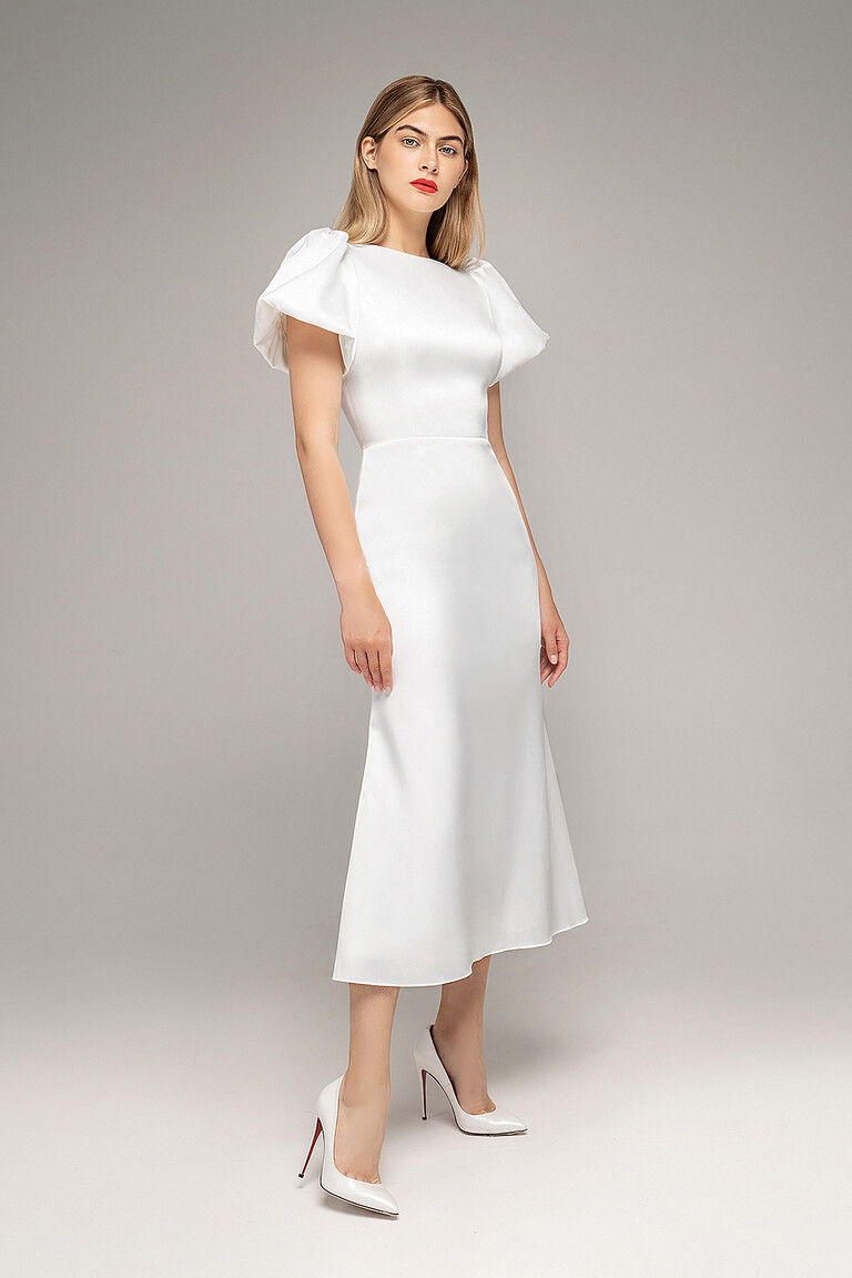 Three-quarter view of Unona Audrey-1 midi ivory wedding dress highlighting the rounded neckline and puff sleeves.