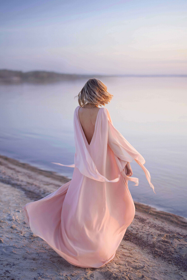 Full back view of the Unona Joan A-line evening dress in powder chiffon, showing the low V-back and long flowing bell sleeves.