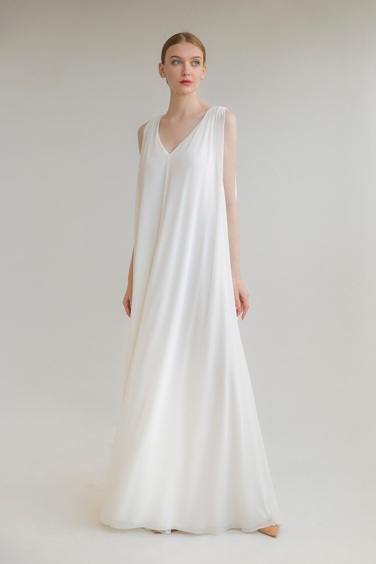 Full front view of the Unona Joan bridal gown in ivory. A sleeveless chiffon dress with a deep V-neck and A-line skirt.
