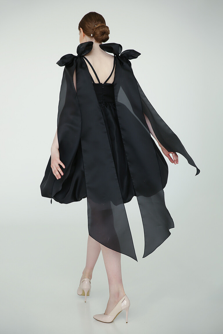 Back view of Leoni black party dress showing multi-strand spaghetti straps and elegant sheer trailing bows.