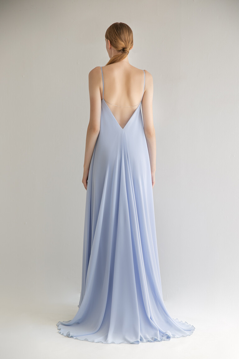 Back view of the Unona Isa blue evening gown in chiffon. Features a deep V-cut open back with a delicate decorative chain.