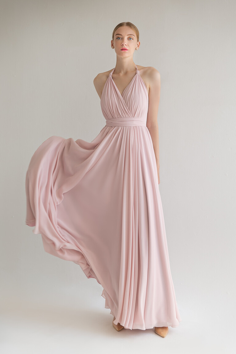 The Unona Calypso powder evening gown in motion, showing the flowing A-line skirt and halter wrap-front bodice