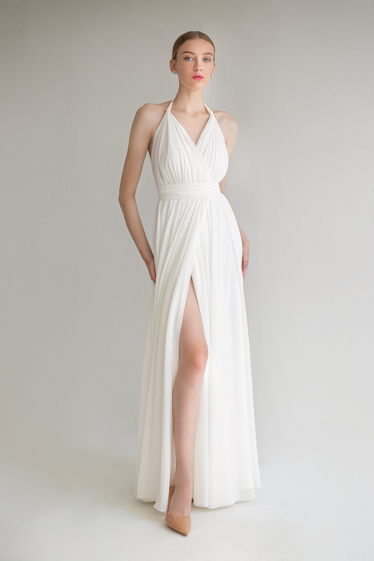 Front view of the Unona Calypso ivory wedding dress highlighting the flowing A-line skirt with an elegant high thigh slit.