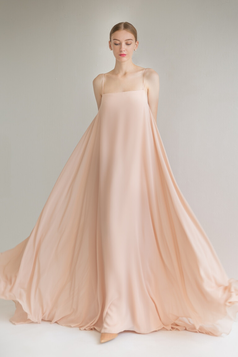 Full front view of the minimalist Isa dress in peach chiffon with a straight neckline and sleeveless A-line design.