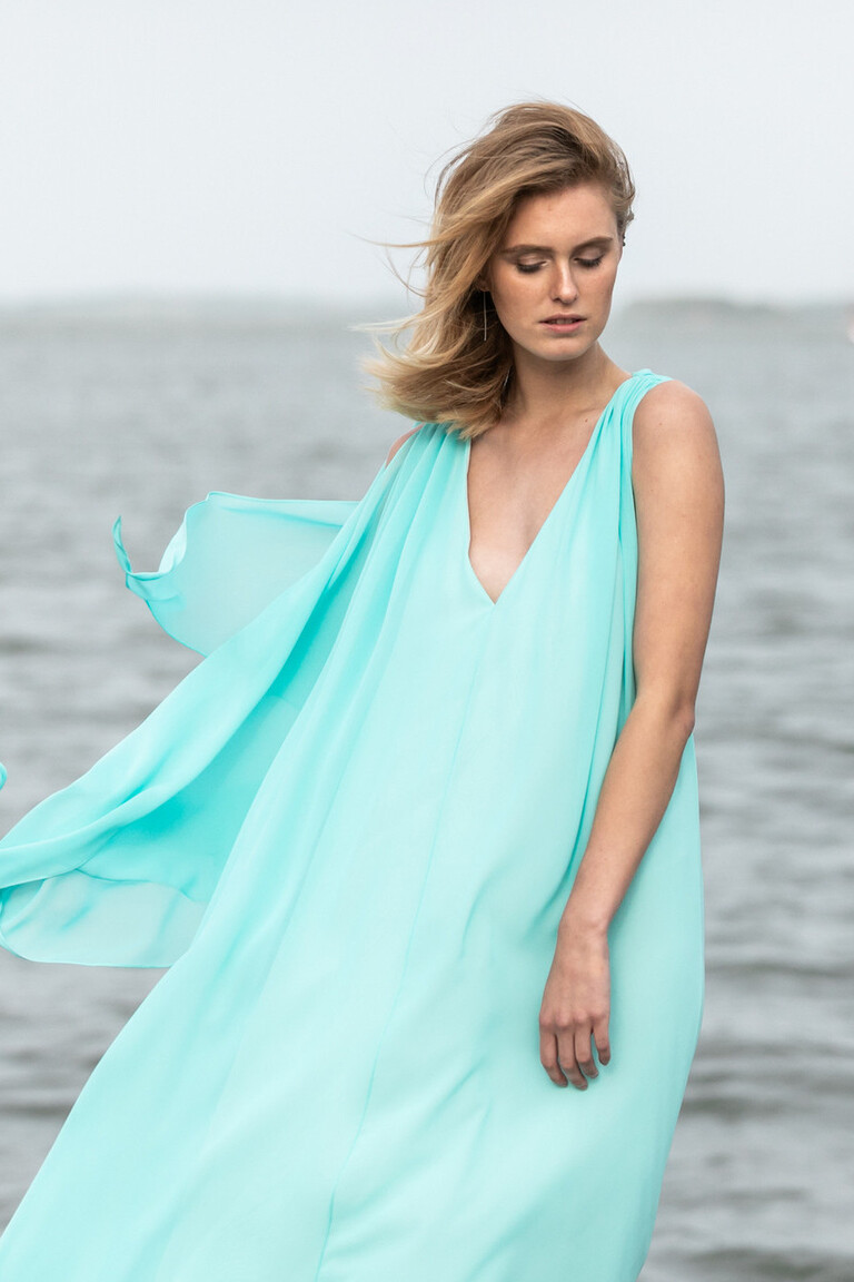 The Ethereal Joan Gown by the Water Medium front shot of the Joan evening dress in Tiffany Blue focusing on the deep V-neckline and floaty chiffon fabric