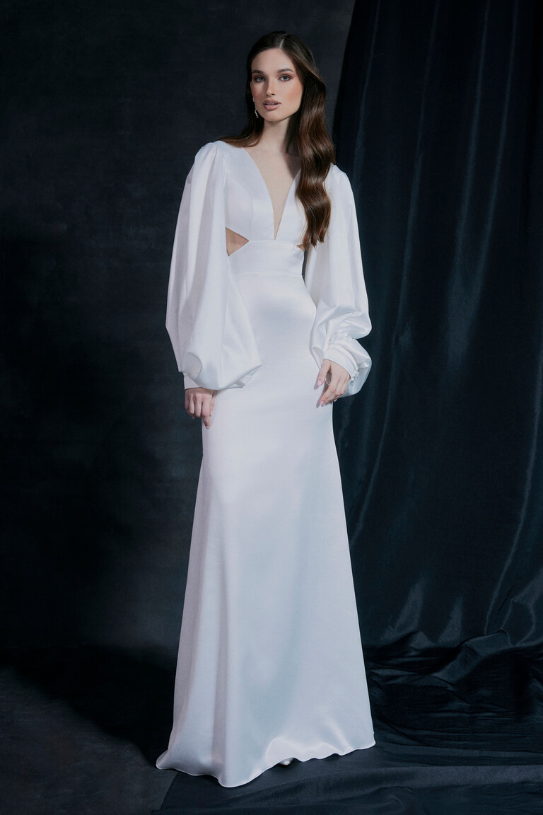 Glamorous Hannah Ivory Satin Wedding Dress Hannah sexy ivory satin wedding dress with long sleeves and plunge neckline posed against a dark glamorous background.