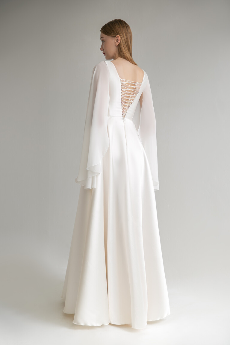 Back view of Edite ivory A-line wedding dress showing the classic corset lace up closure and sheer chiffon cape sleeves