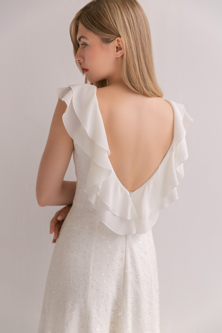 Close-up back view of the Alison boho wedding dress showcasing the deep open V-back, chiffon flounces, and subtle sequins.