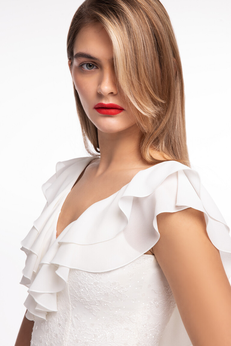 Close-up of the Alison ivory wedding dress bodice showcasing a deep V-neck, cascading chiffon ruffles, and sequined lace.