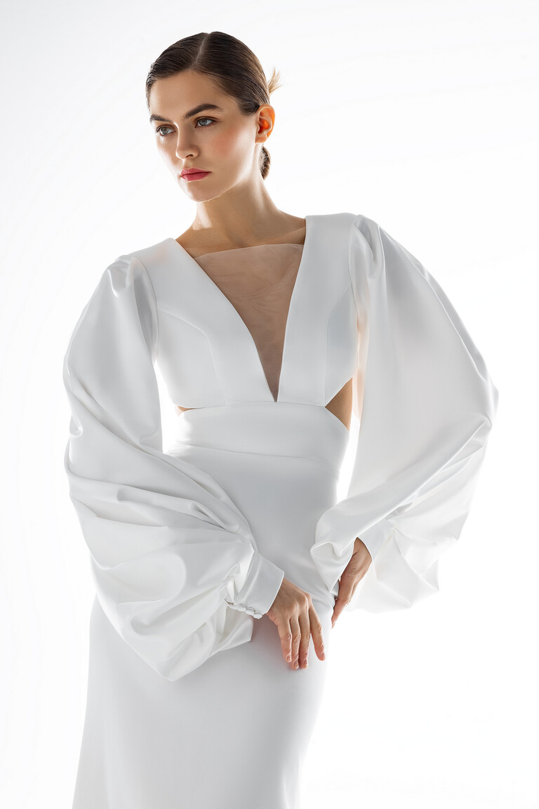 Hannah Bodice Detail with Plunge Neck and Balloon Sleeves Bodice detail of Hannah ivory wedding dress showing plunge V-neck, side cutouts, and balloon sleeves with button cuffs.