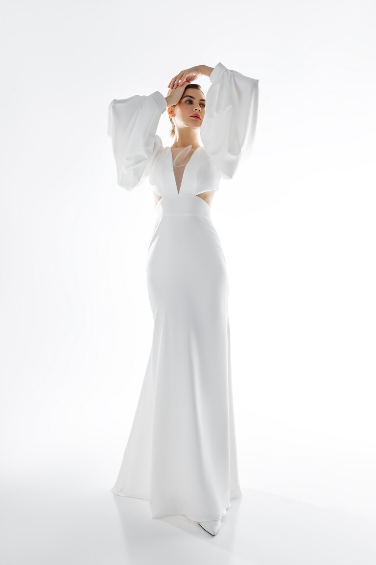Elegant Hannah Mermaid Silhouette Bridal Dress Elegant Hannah ivory mermaid wedding dress with illusion plunge neck, side cutouts, and long sleeves in stretch satin.