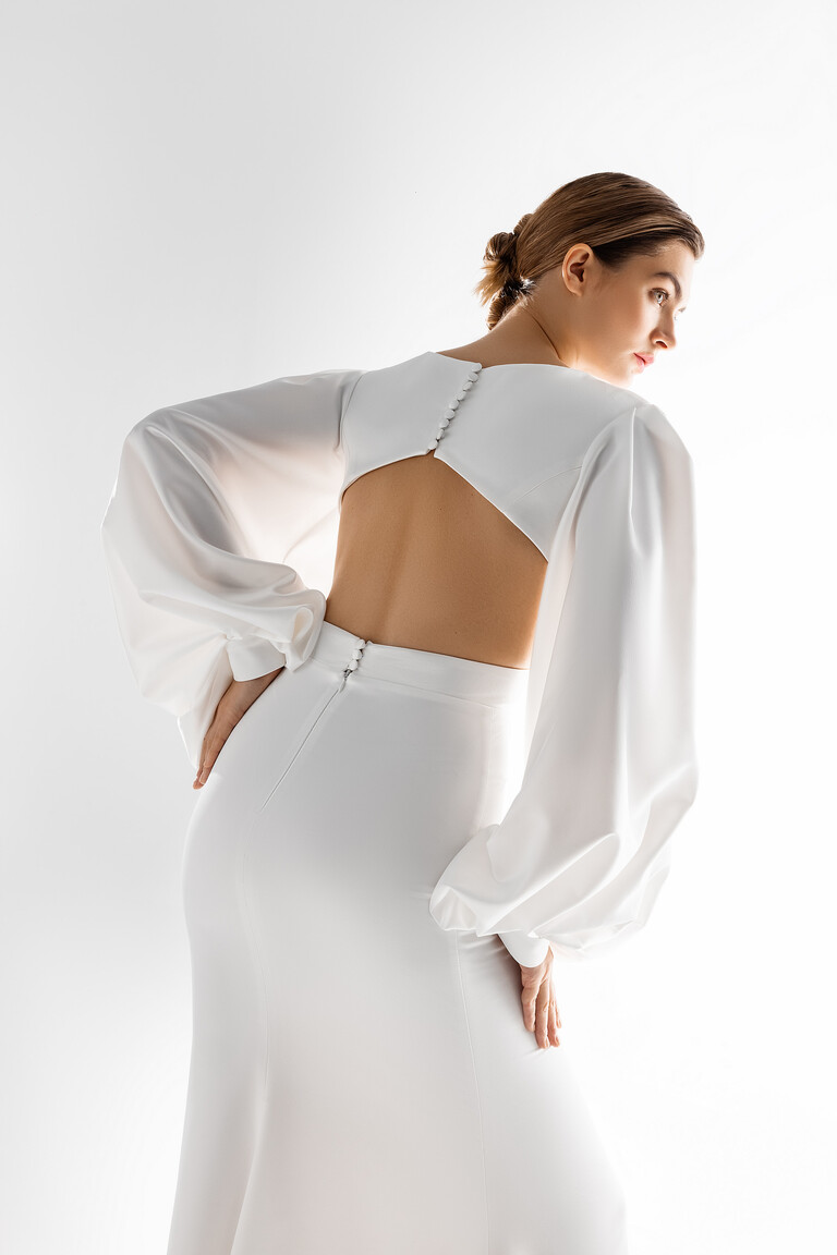 Hannah Open Back Detail with Delicate Buttons Back view of Hannah ivory satin bridal gown featuring an elegant open back cutout, delicate buttons, and voluminous sleeves.