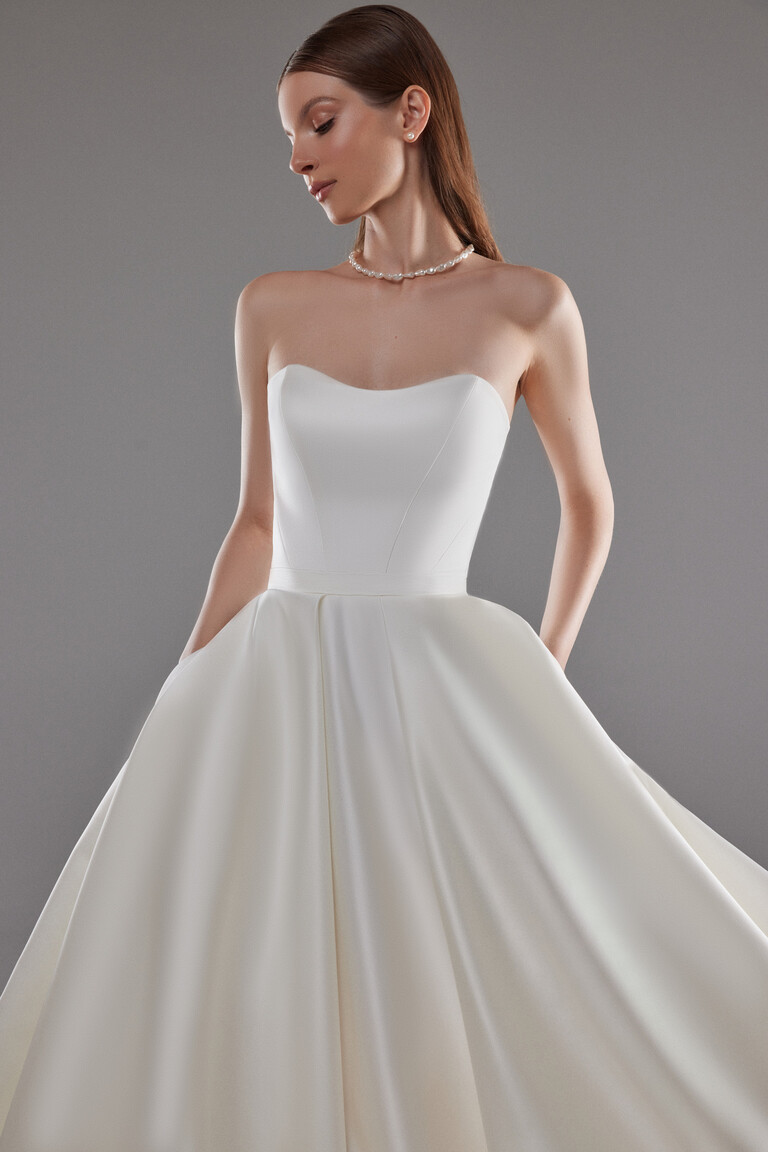 Close-up front view of Lizzie ivory satin strapless bodice with sweetheart neckline and pockets.