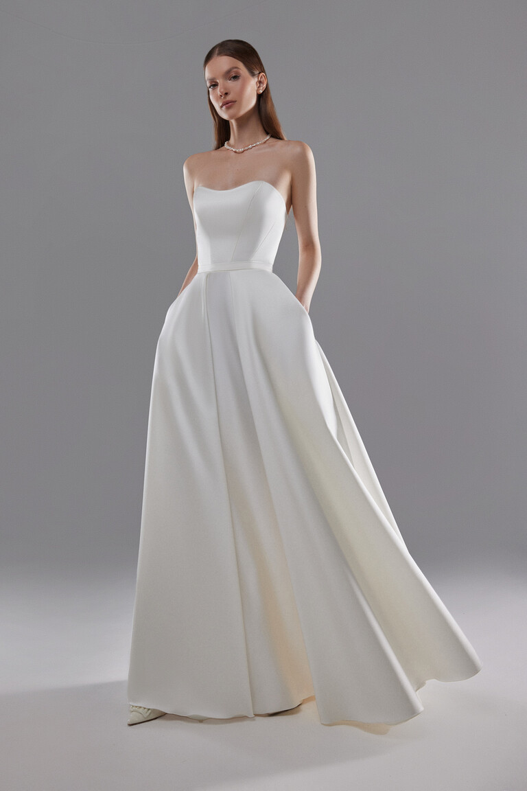 Lizzie Satin A-Line Bridal Gown with Pockets Front angle of Lizzie ivory satin A-line wedding dress with strapless sweetheart neckline and side pockets.
