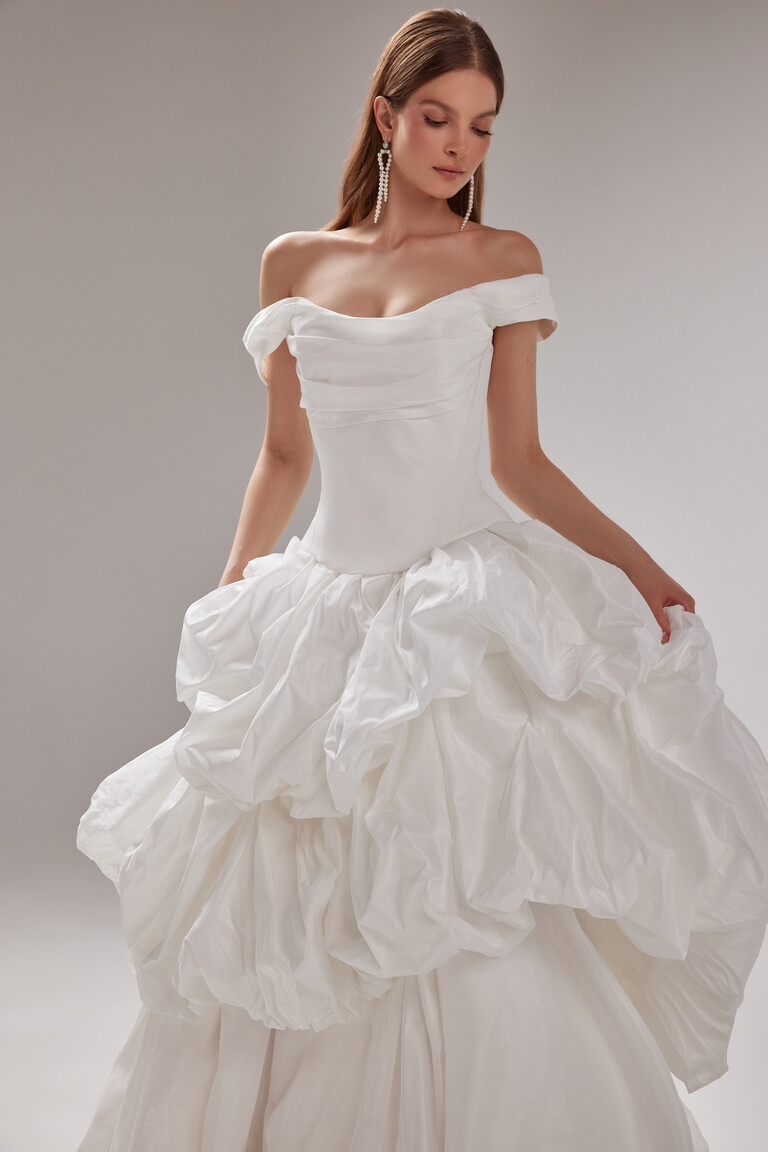 Paradise Layered Ruffled Taffeta Bridal Gown with Drop Waist by Unona Paradise off-shoulder taffeta bridal gown front view. Features a corset bodice and layered ruffled skirt with a drop waist.